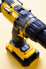 Detail of yellow battery powered drill on color background