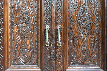 Engraved wooden doors of an old classic cabinet. Antique wooden textures concept.