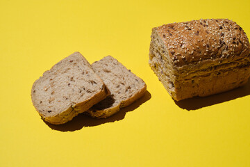 Bread. Sliced  bread's loaf with seeds on a yellow background. Healthy Diet. sliced organic bread. Top view. Artisan bread with seeds. Rustic sourdough bread.