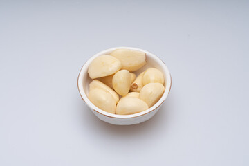 Minced and peeled garlic on a white background