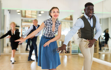 Fototapeta premium Woman with african man practising charleston dancing