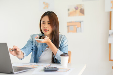 Construction design concept, Female architect talking on smartphone during sketching house plan