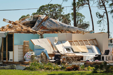 Severely damaged by hurricane Ian house in Florida mobile home residential area. Consequences of natural disaster