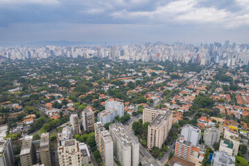 Obraz premium Rainy day in the Jardins neighborhood located in the city of São Paulo, capital. Dark clouds, buildings, cars, trees and pedestrians circling.