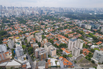 Fototapeta premium Rainy day in the Jardins neighborhood located in the city of São Paulo, capital. Dark clouds, buildings, cars, trees and pedestrians circling.