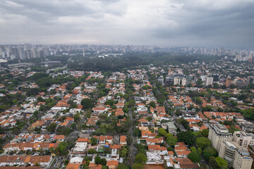 Rainy day in the Jardins neighborhood located in the city of S&atilde;o Paulo, capital. Dark clouds, buildings, cars, trees and pedestrians circling.
