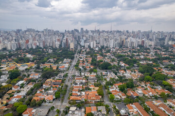 Rainy day in the Jardins neighborhood located in the city of São Paulo, capital. Dark clouds, buildings, cars, trees and pedestrians circling.
