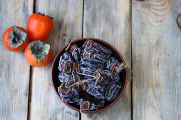 Dried persimmon in a bowl. Autumn fruits. Dried fruits.