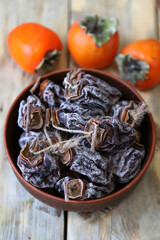 Dried persimmon in a bowl. Autumn fruits. Dried fruits.