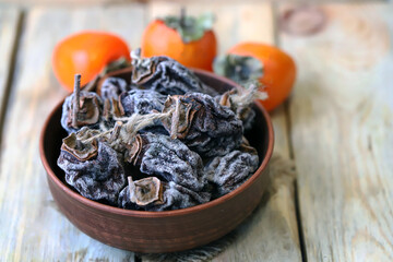 Dried persimmon in a bowl. Autumn fruits. Dried fruits.