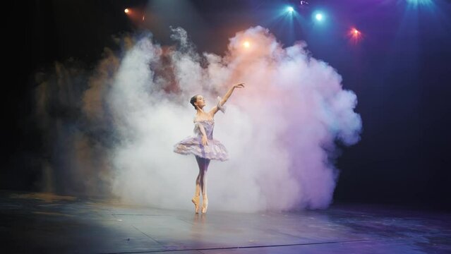 Ballet. Graceful ballerina dancing elements of classical ballet in the beautiful light and smoke on the background, High quality 4K footage 