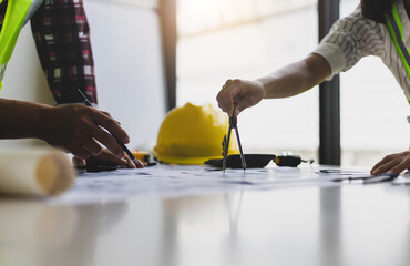 Architect and engineer colleagues brainstorm design work on blueprint planning ideas of construction projects. Construction engineering design inspector team.