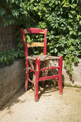 Fototapeta na wymiar Old weathered grunge wooden chair in house yard corner