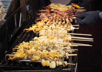 Fresh squid skewered on a charcoal grill ready to eat for grilled seafood barbecue. - 537030425