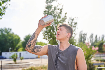 young athlete splashing water on his face while training