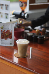 Closeup of Iced Caramel Macchiato at the coffee shop, Caramel Macchiato is a classic macchiato beverage. It consists of vanilla syrup, espresso, steamed milk, foam, and caramel drizzle