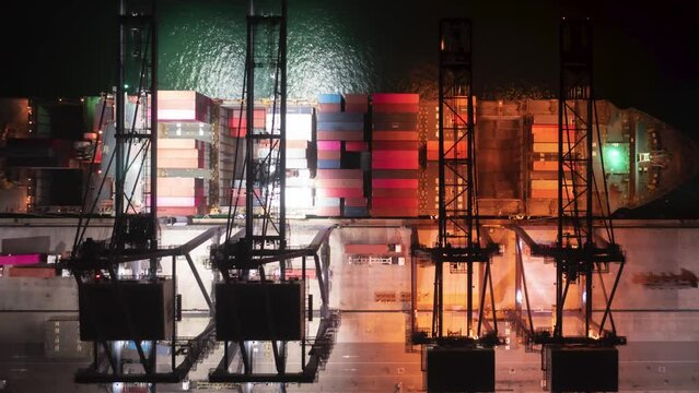 Aerial Time lapse container ship carrying container in import export business logistic at night.