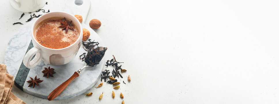 Masala tea. Masala chai spiced tea with milk and spices on light grey background. Traditional indian drink. Spice drink. Copy space. Selective focus. Banner and Mock up.
