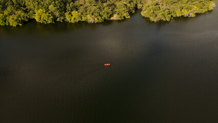 Aerial overhead shot of orange kayak on wild river during sunshine in Argentina