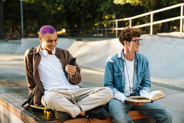 Two young handsome stylish smiling boys sitting togehter