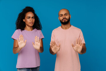 Black young man and woman making stop gesture at camera