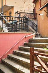 Stairs in the old city, vertical frame, selective focus on the railing, idea for a postcard or background for advertising