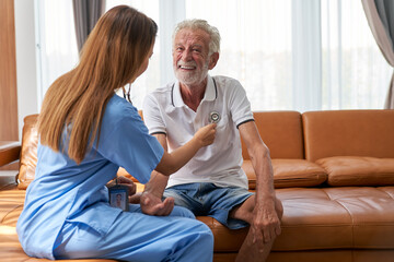Home Health Care Service concept , Nurse check health of oldly patient in home by stethoscope.