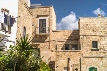 Fototapeta na wymiar Spectacular medieval stone houses in the old town of Polignano a Mare built on the cliffs above the Adriatic Sea Narrow streets and historic buildings