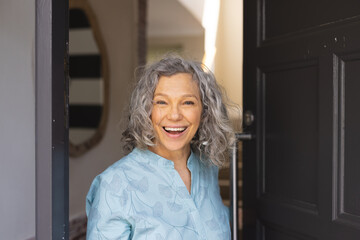 Happy african senior caucasian women opening door and welcoming somebody - Powered by Adobe