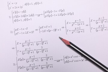 Sheet of paper with mathematical formulas and pencil, top view