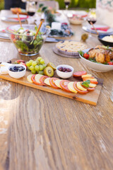 Vertical picture of a wooden table prepared for a meal in the sunny garden
