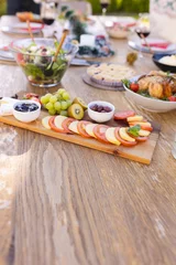 Foto op Aluminium Vertical picture of a wooden table prepared for a meal in the sunny garden © WavebreakMediaMicro