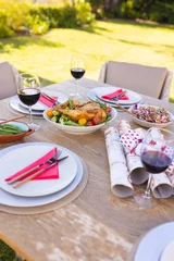 Foto op Aluminium Vertical picture of a wooden table prepared for a meal in the sunny garden © WavebreakMediaMicro