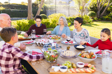 Caucasian family spending time together outside and praying before meal