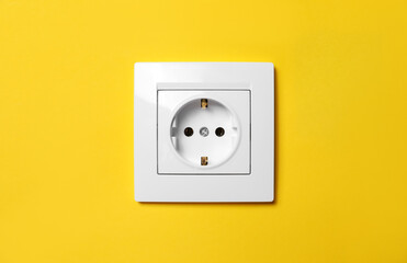 Power socket on yellow wall. Electrical supply - obrazy, fototapety, plakaty