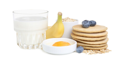 Tasty oatmeal pancakes and ingredients on white background