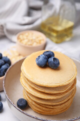 Tasty oatmeal pancakes with blueberries in bowl, closeup