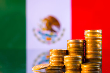 A stack of gold coins on the background of the flag of Mexico. Country economy concept