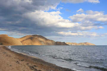 Fototapeta na wymiar The beach is a quiet bay in the Crimea, a beautiful landscape on a cloudy day.