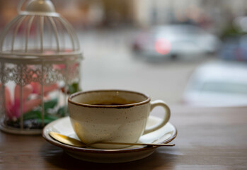 Cup of coffee on the table in a coffee shop. A cup of coffee is on the table by the window.