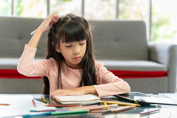 Asian girl doing her own homework at home