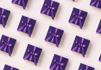 Christmas pattern. Violet gift box with a purple bow made of satin pattern on soft beige...