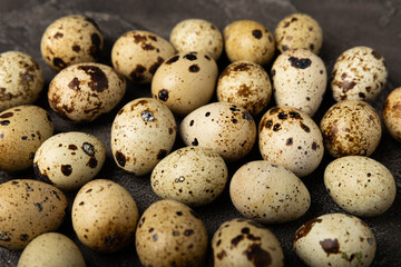 Obraz premium Quail eggs on black texture background. Whole and broken quail eggs. Natural products. Place for text. Fresh quail eggs. Protein. Calcium.