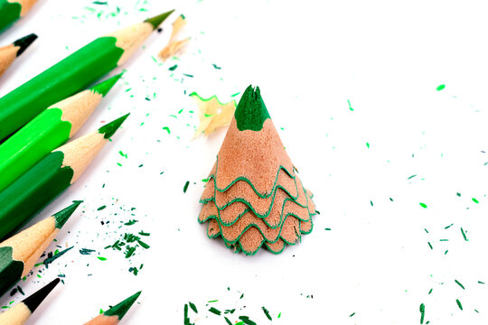 Colored pencils and creative Christmas tree made of shavings from a green pencil.Christmas and New Year flat lay on a white background.