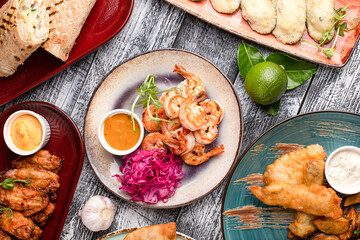 Table with various snacks, snacks for everyone on a wooden white background