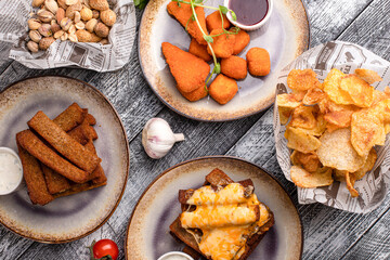 Table with various snacks, snacks for everyone on a wooden white background