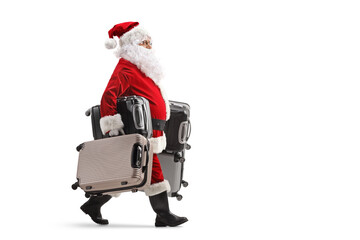 Full length profile shot of santa claus walking and carrying many suitcases