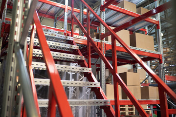 industrial mezzanine. Multi-tier shelving systems. Industrial mezzanine inside building. Steel warehouse furniture with cardboard boxes. Staircase at mezzanine. Semi-permanent production structures - obrazy, fototapety, plakaty