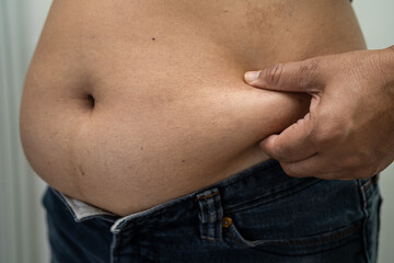 Naklejka premium Overweight Asian woman show fat belly at office.