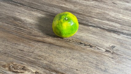 High angle of an orange on a wooden table.